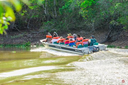 a group of people in a boat on a river at Hotel Pantanal Mato Grosso in Poconé