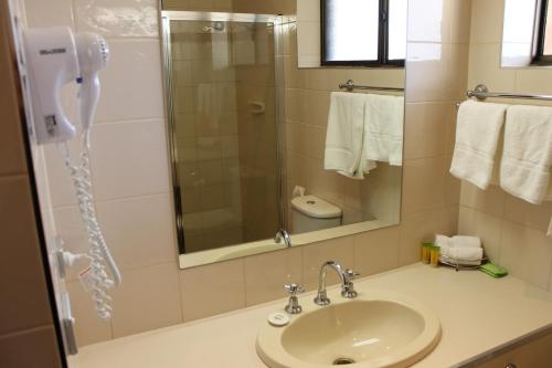 a bathroom with a sink and a shower with a phone at Bakery Hill Motel in Ballarat
