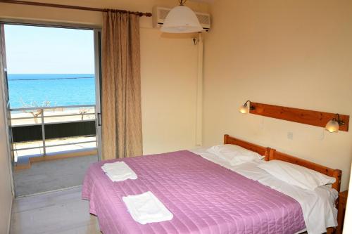 a bedroom with a bed with a view of the ocean at Pantelis in Poros