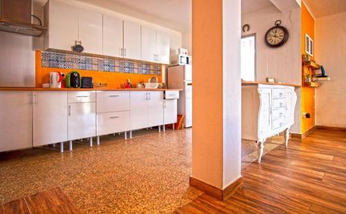 a kitchen with white cabinets and a clock on the wall at Inn Golegã in Golegã