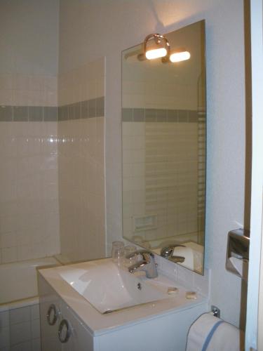 a bathroom with a sink and a mirror and a tub at Hôtel Continental in Vierzon