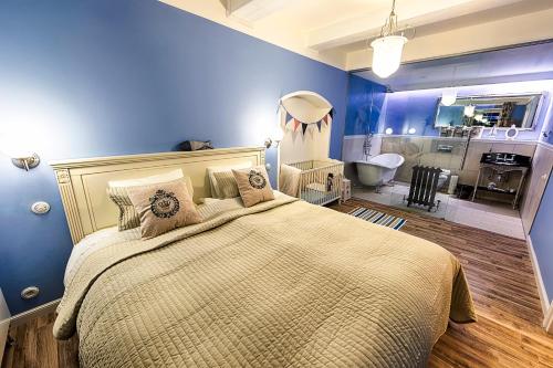 a blue bedroom with a large bed and a bathroom at Chateau Nightingales in Hostouň