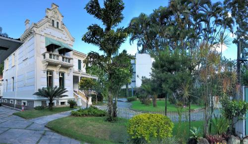 an old white building with a tower at Hotel Casablanca Imperial in Petrópolis