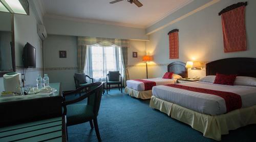 Habitación de hotel con 2 camas y escritorio en Hotel Seri Malaysia Genting Highlands, en Genting Highlands
