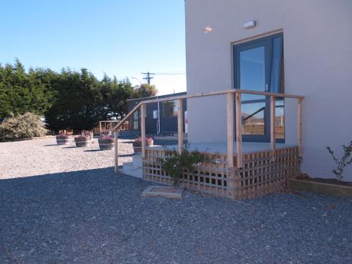 a house with a glass door on the side of it at Wheels and Reels Accommodation in Mossburn