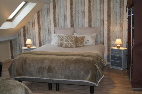 a bedroom with a large bed with two night stands and two lamps at La Citadine in Bayeux