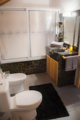 a bathroom with a toilet and a sink at Stone Dreams - Pedra da Atafona in Calheta de Nesquim