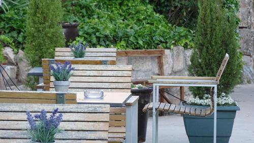 a garden with two benches and a table and a chair at Hotel Cardamomo Sigüenza in Carabias