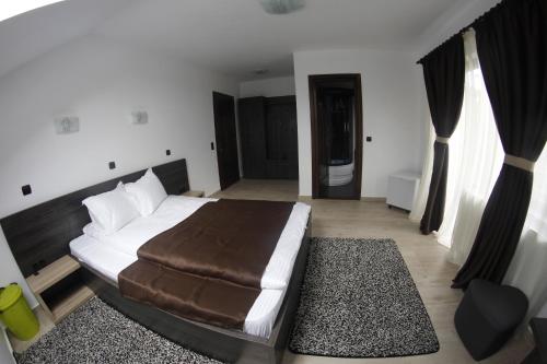 a bedroom with a large bed with a brown blanket at Casa Laur cu plajă privată in Colibiţa