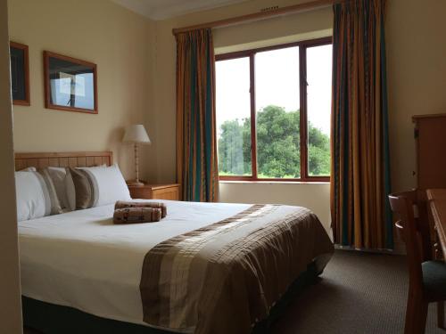 sypialnia z dużym łóżkiem i dużym oknem w obiekcie Keurbooms River Lodge 1014 w mieście Plettenberg Bay