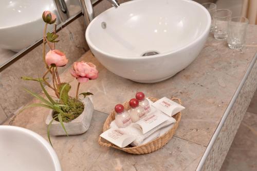 a bathroom counter with a sink and a basket of toiletries at Hotel Ruinas in Cusco