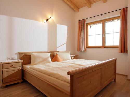 a bedroom with a large wooden bed with a window at Landhaus Lindner in Westendorf