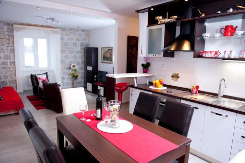 eine Küche und ein Esszimmer mit einem Tisch, einer Küche und einer Küche in der Unterkunft Apartman u srcu grada - Ilićev prolaz in Split