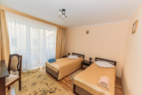 a bedroom with two beds and a large window at Apartments Sonce in Truskavets