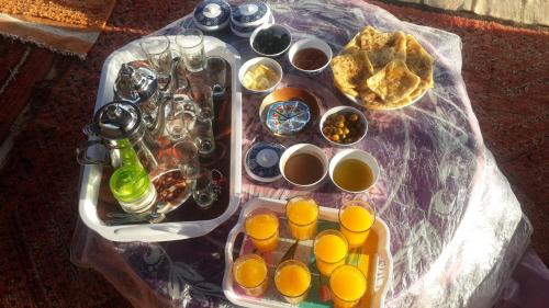 a table with a tray of oranges and cups of coffee at Oasis de Tiout in Tiout