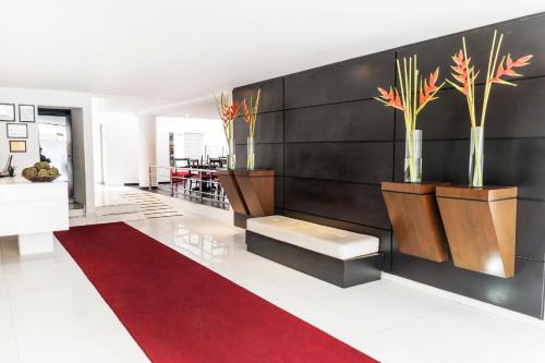 a lobby with a red carpet and vases with plants at Hotel Bogota Virrey in Bogotá