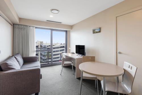 a living room with a couch and a table and a desk at The Chancellor on Hobson in Auckland