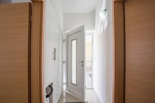 a hallway with a white door and a mirror at Guest House Croatia in Fažana