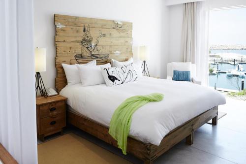 a bedroom with a bed with a wooden headboard at Hotel El Ganzo - Adults Only in San José del Cabo