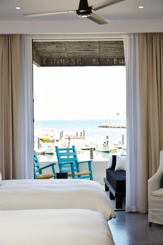 a hotel room with two beds and a view of the ocean at Hotel El Ganzo - Adults Only in San José del Cabo