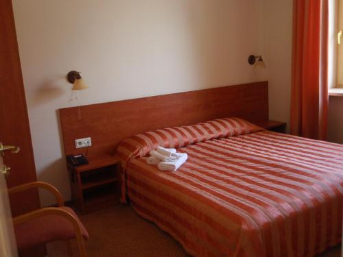 a hotel room with a bed with towels on it at Hotel-Restaurant Smilga in Kėdainiai