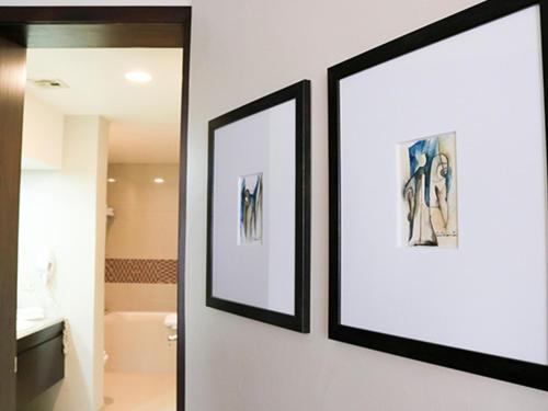 deux photos encadrées accrochées à un mur dans une salle de bains dans l'établissement Hotel Coral & Marina, à Ensenada