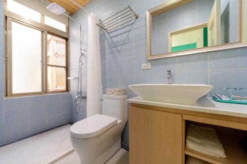 a bathroom with a sink and a toilet and a mirror at Bella Cottage in Puli
