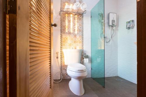 a bathroom with a toilet and a glass shower at 777 Food & Bed in Chiang Rai