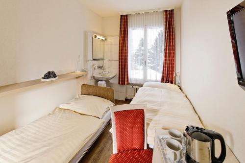 ein Krankenhauszimmer mit 2 Betten und einem Waschbecken in der Unterkunft Hotel Beausite Budget in Interlaken