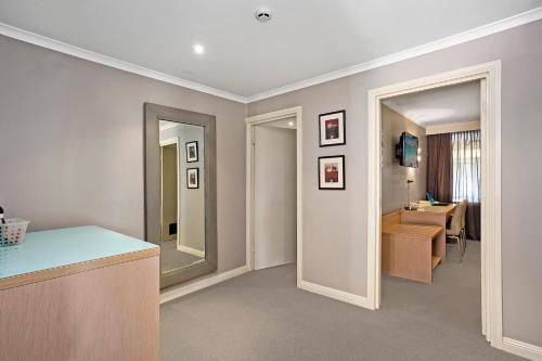a bathroom with a vanity and a sink and a mirror at Best Western Sanctuary Inn in Tamworth