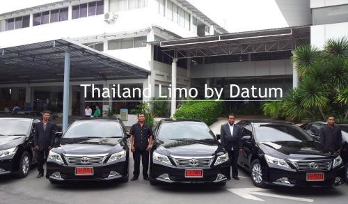 Un gruppo di uomini davanti a tre auto. di Homeplace Residence a Bangkok