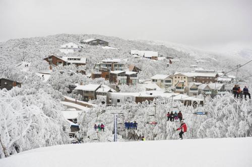 a group of people on a ski lift in the snow at Mt Buller Chalet Hotel & Suites in Mount Buller
