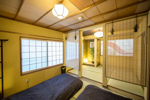 京都市にあるアズーロ エレファンテの青いベッド1台、窓2つが備わります。