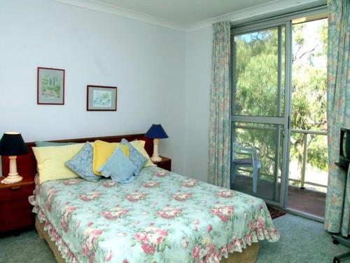 a bedroom with a bed and a large window at Blue Waters Unit 8 59 Ronald Avenue in Shoal Bay