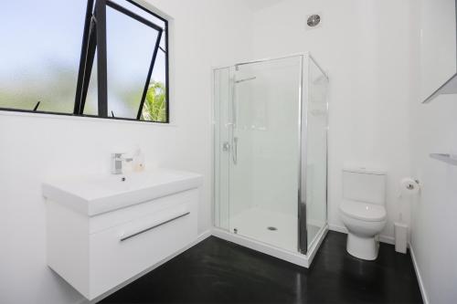uma casa de banho com um lavatório, um chuveiro e um WC. em Mata Manea em Rarotonga
