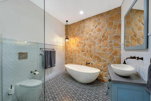 Belle Vue- Penthouse at Black Beach في كياما: حمام مع حوض ومغسلة ودش