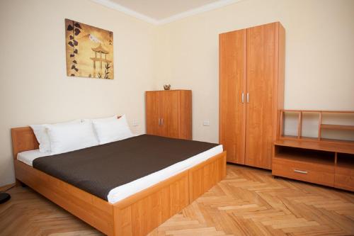モスクワにあるInnDays on Belorusskayaのベッドルーム1室(ベッド1台付)、木製キャビネットが備わります。