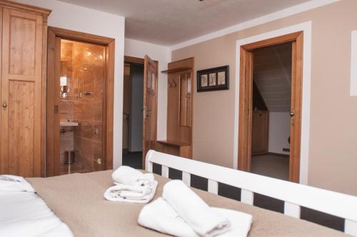 a bedroom with a bed with towels on it at Pension Konírna in Huntířov