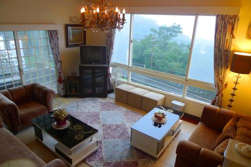 a living room with a large window and a couch at Villa High Wharf in Wanli District