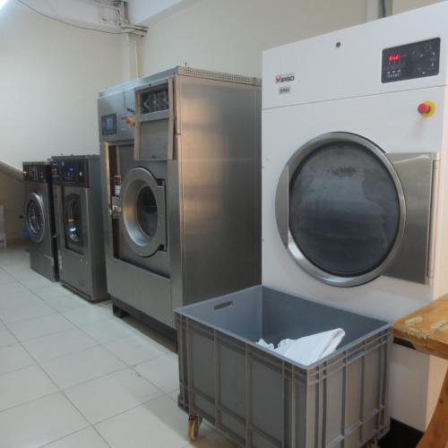a laundry room with three washing machines and a washer and dryer at Royal Hotel in Baku
