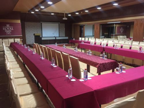 a conference room with pink tables and chairs at Royal Hotel in Baku