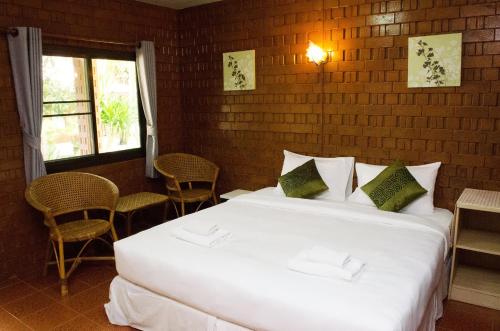 a bedroom with a large white bed and a window at Ban Krut Resort in Ban Krut