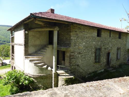 a stone house with stairs on the side of it at La Bouriotte in Labastide-Rouairoux