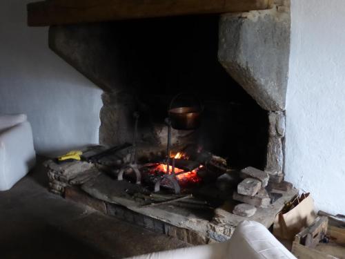 a brick oven with a pot over a fire at La Bouriotte in Labastide-Rouairoux