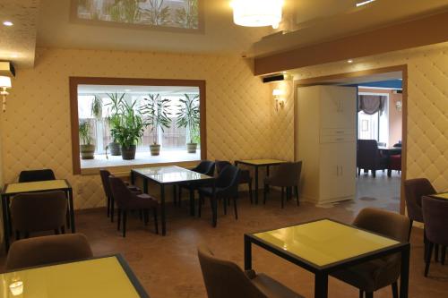 a restaurant with tables and chairs and a window at Non-stop hotel in Boryspilʼ
