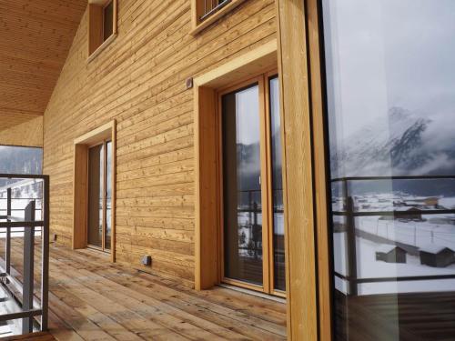 a wooden house with glass doors on a balcony at Sport Hotel in Livigno