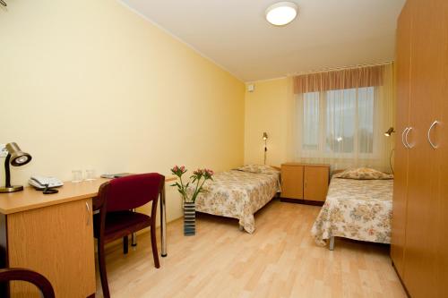 Habitación con 2 camas, escritorio y mesa. en Mardi Hotel, en Kuressaare