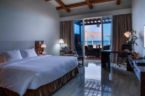 a bedroom with a bed and a view of the ocean at Danat Jebel Dhanna Resort in Jebel Dhanna