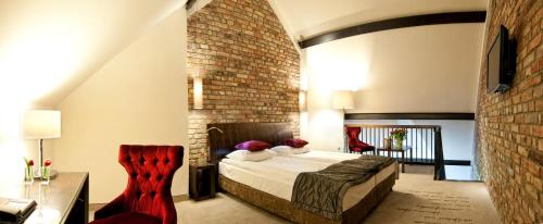 sypialnia z łóżkiem i ścianą z cegły w obiekcie Hotel Remes w mieście Opalenica