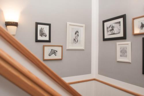 a hallway with framed pictures on the wall at Pension Konírna in Huntířov